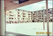 Osiedle mieszkaniowe w dzielnicy Slotervaart w zachodniej części miasta, widok z podcienia na dziedziniec wewnętrzny otoczony pięciokondygnacyjnymi budynkami mieszkalnymi z parterami sklepowymi, Amsterdam, Niderlandy