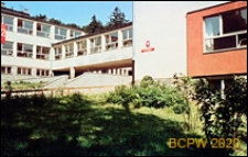 Szkoła podstawowa, widok zewnętrzny z widocznym na elewacji godłem i tablicą szkoły, łącznikiem oraz terenem zielonym, Gdańsk-Wrzeszcz