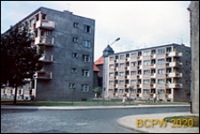 Nowa Brama, fragment budynku i pięciokondygnacyjne bloki mieszkalne z zielonymi terenami międzyblokowymi, Słupsk