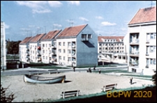 Trzykondygnacyjne budynki mieszkalne, w tle powstające nowe bloki oraz pawilony, widok od strony wnętrza międzyblokowego, Stargard